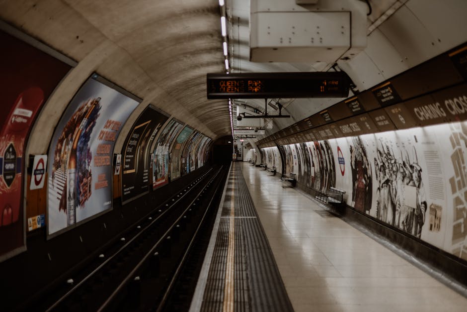 Inside a London Underground station near High Street Kensington, showing a clean, well-lit platform with a yellow train on the left. The surface of the platform appears smooth and free of dust or debr